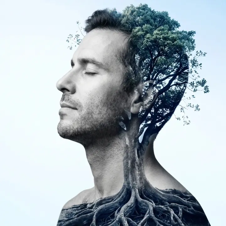Profilo di uomo in doppia esposizione con un albero e le sue radici